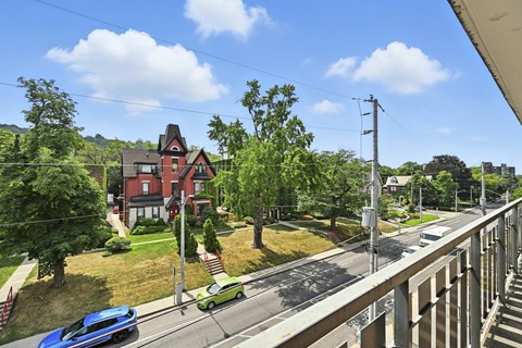 A red house with a green car parked in front.