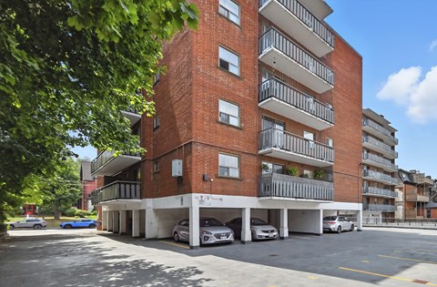 A red brick building with a parking lot in front.