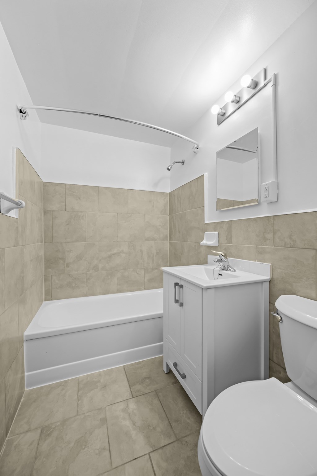 A white toilet sits next to a bathtub in a bathroom.