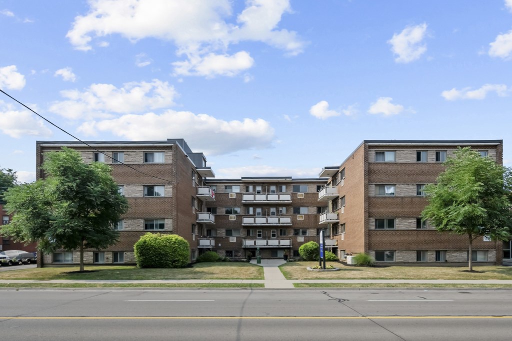 A large apartment complex with a green lawn in front.