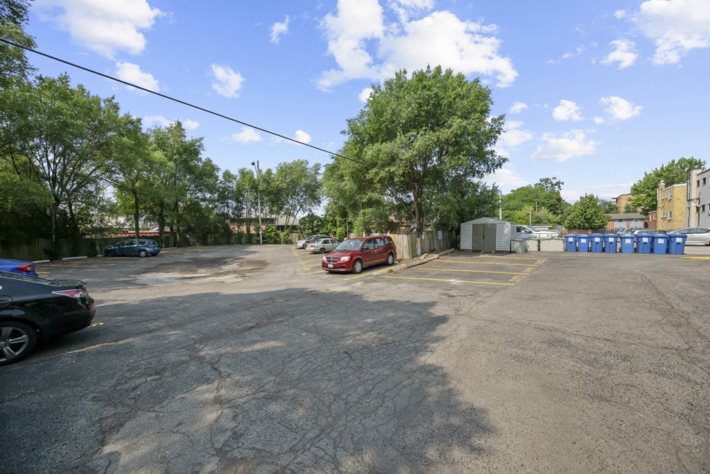 A parking lot with a few cars and trees.