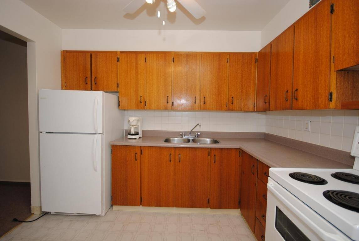 A kitchen with wooden cabinets and white appliances.
