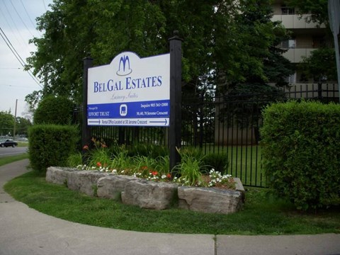 A sign for Belg Estates with a blue background and white text.