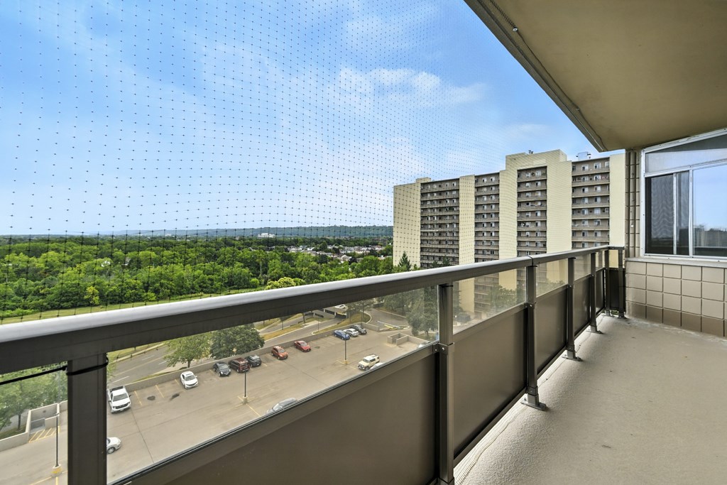 A balcony with a view of a highway and trees.