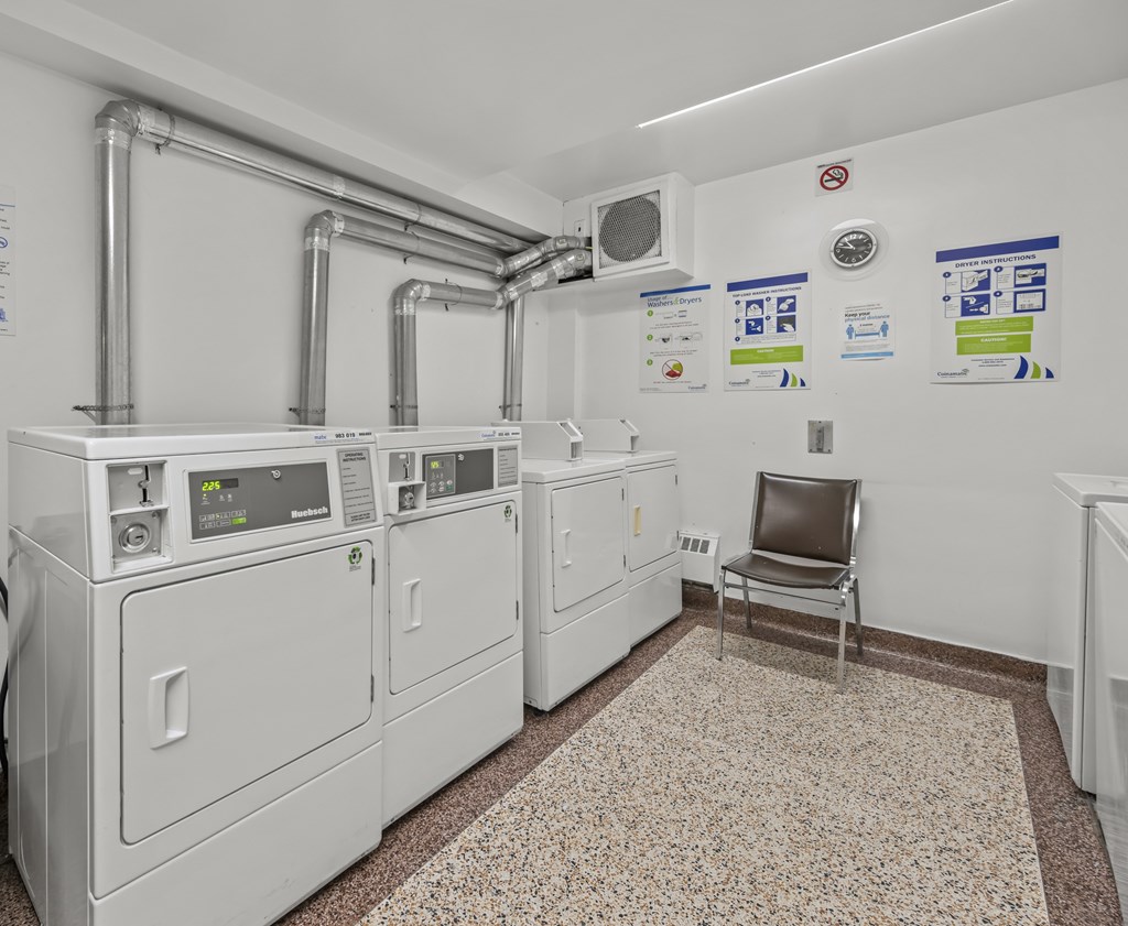 A room with white walls has a chair and a table in it.