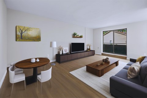 A living room with a wooden table and chairs, a couch, and a painting on the wall.