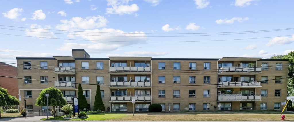 A large apartment building with balconies on the upper floors.