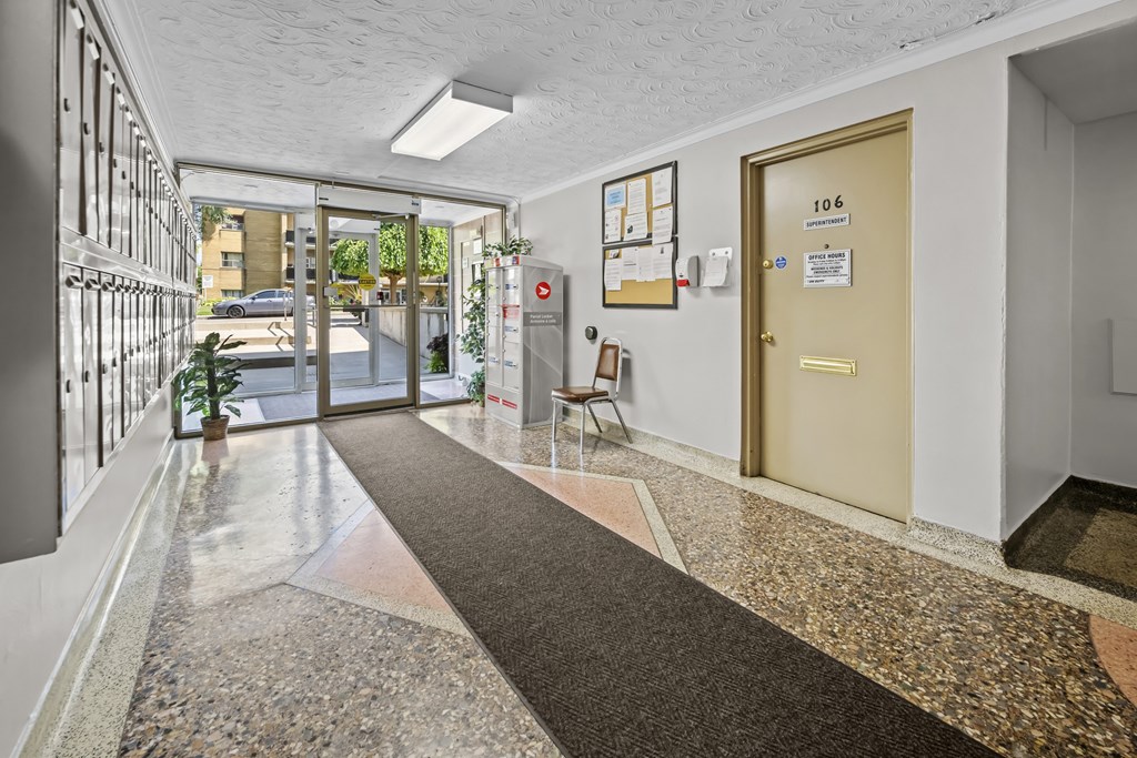 A hallway with a marble floor and a gold door.