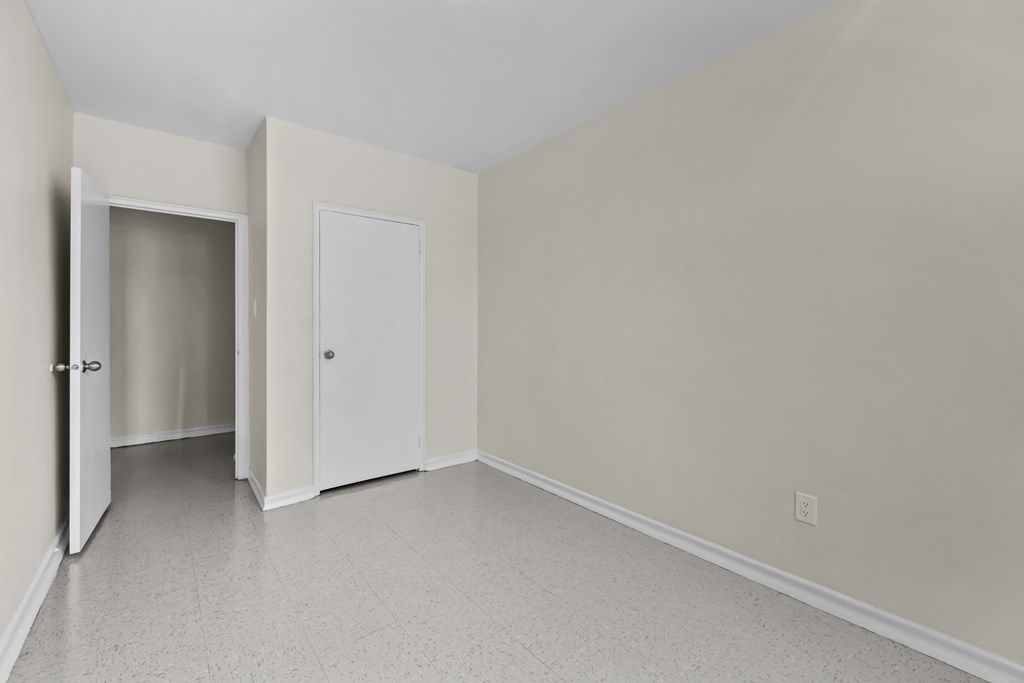 A room with a white door and a white wall.