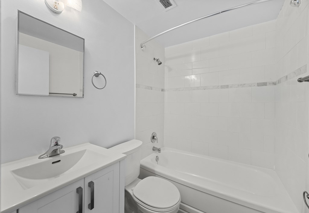 A white bathroom with a toilet, sink, and bathtub.
