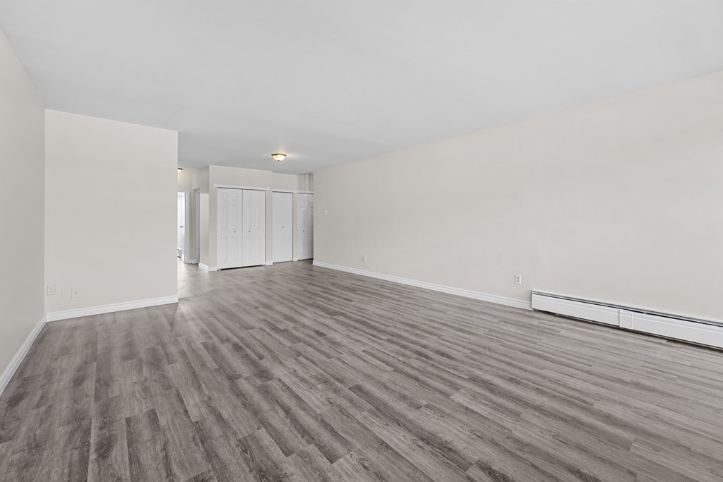 A room with wooden flooring and white walls.