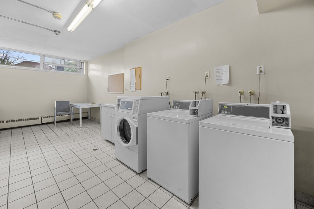 A laundry room with washing machines and a dryer.