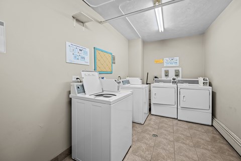 A clean, white-walled laundry room with a washer and dryer.