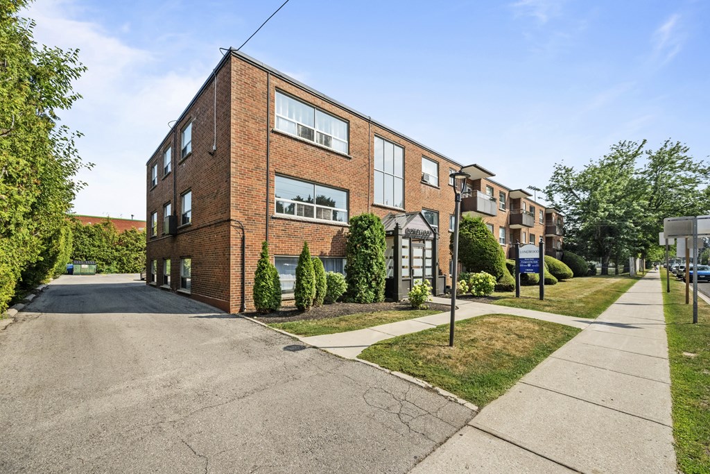 A red brick building with a green lawn in front.