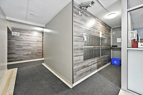 A room with a grey floor and a grey wall with a wood panel design.
