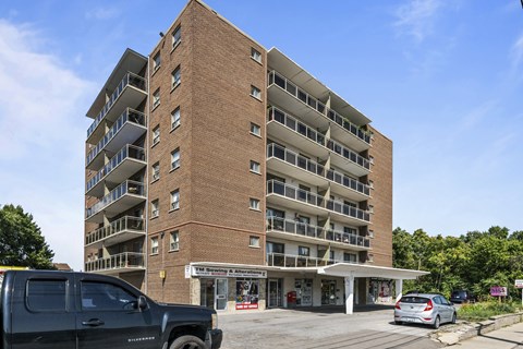 A large brick building with a parking lot in front.