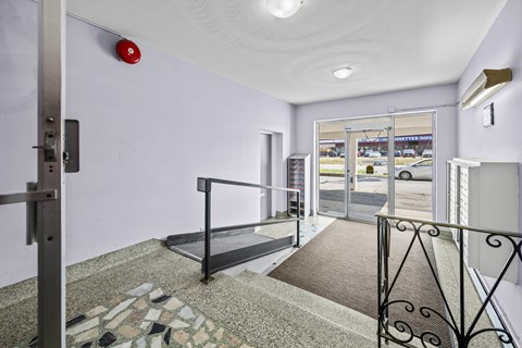A hallway with a red alarm button on the wall.