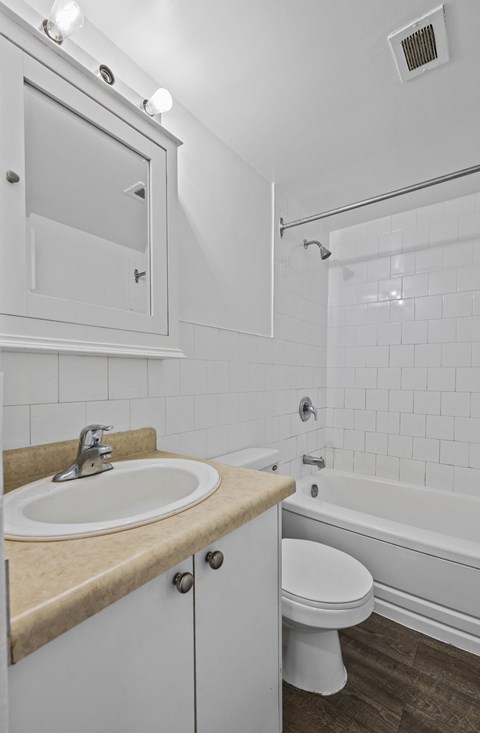 A white bathroom with a sink, toilet, and bathtub.