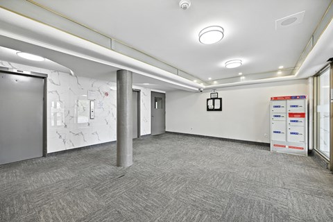 A room with a grey carpet and white walls with a white ceiling and a white door.