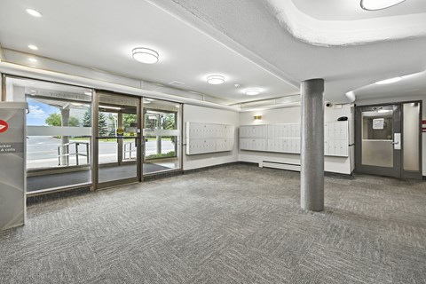 A hallway with a grey carpet and a white ceiling.