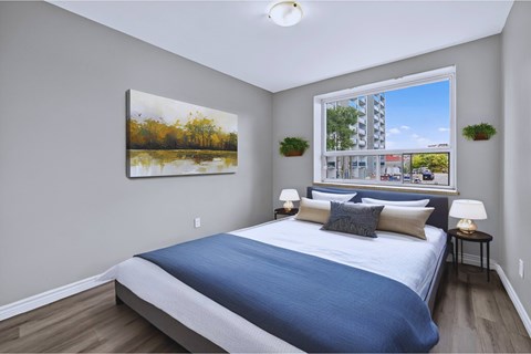 A bedroom with a large bed and a painting on the wall.