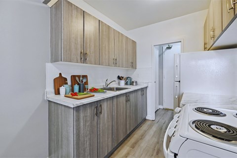A kitchen with wooden cabinets and a white stove top oven.
