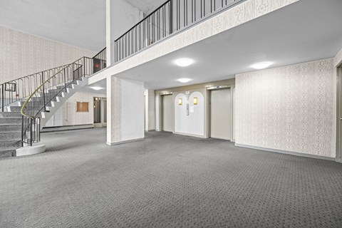 A spacious room with a staircase and two doors.