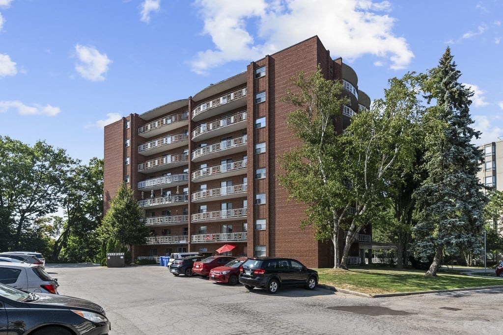 A large red brick building with a parking lot in front.