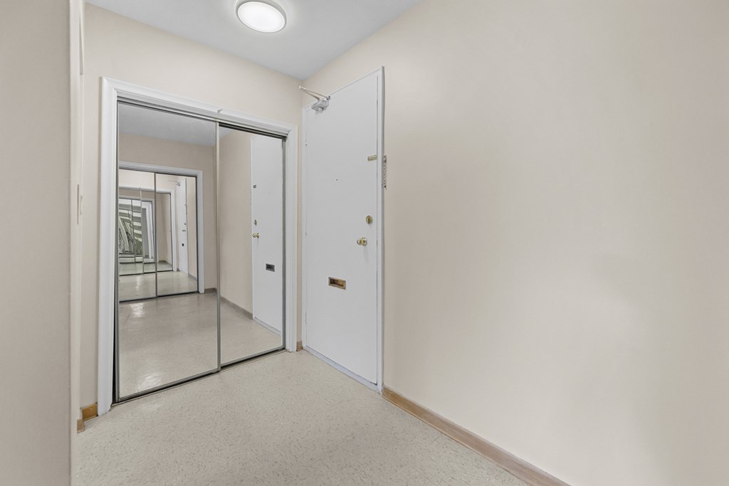 A white door is in a room with a carpeted floor.