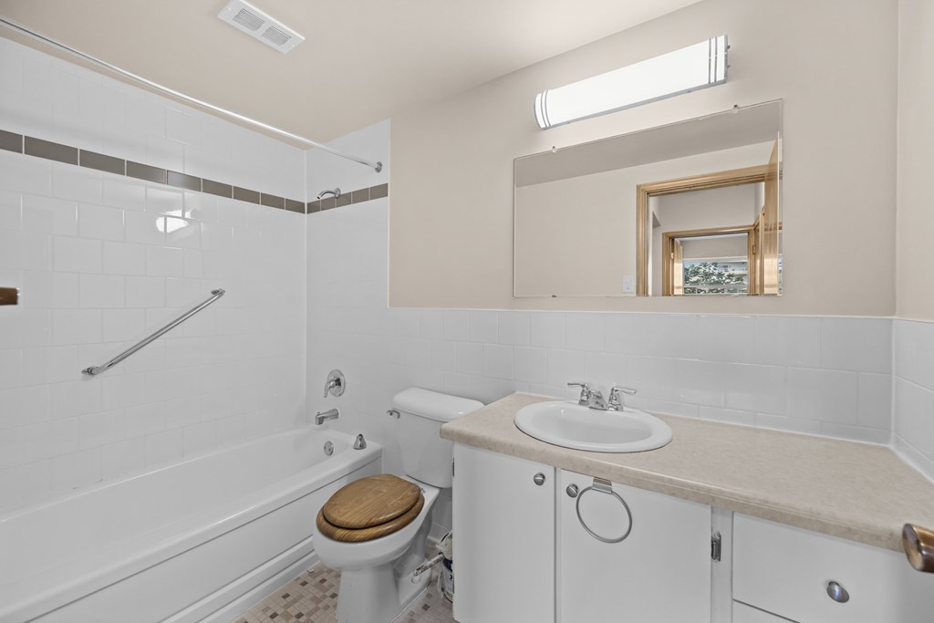 A white bathroom with a toilet, sink, and tub.