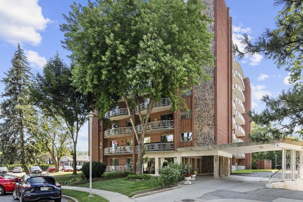 A red car is parked in front of a black car.