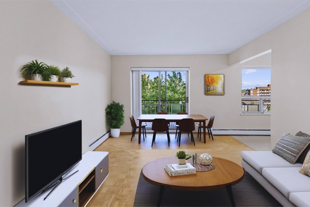 A living room with a television, a sofa, a table, and a dining table with chairs.