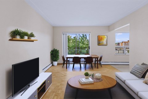 A living room with a television, a sofa, a table, and a dining table with chairs.