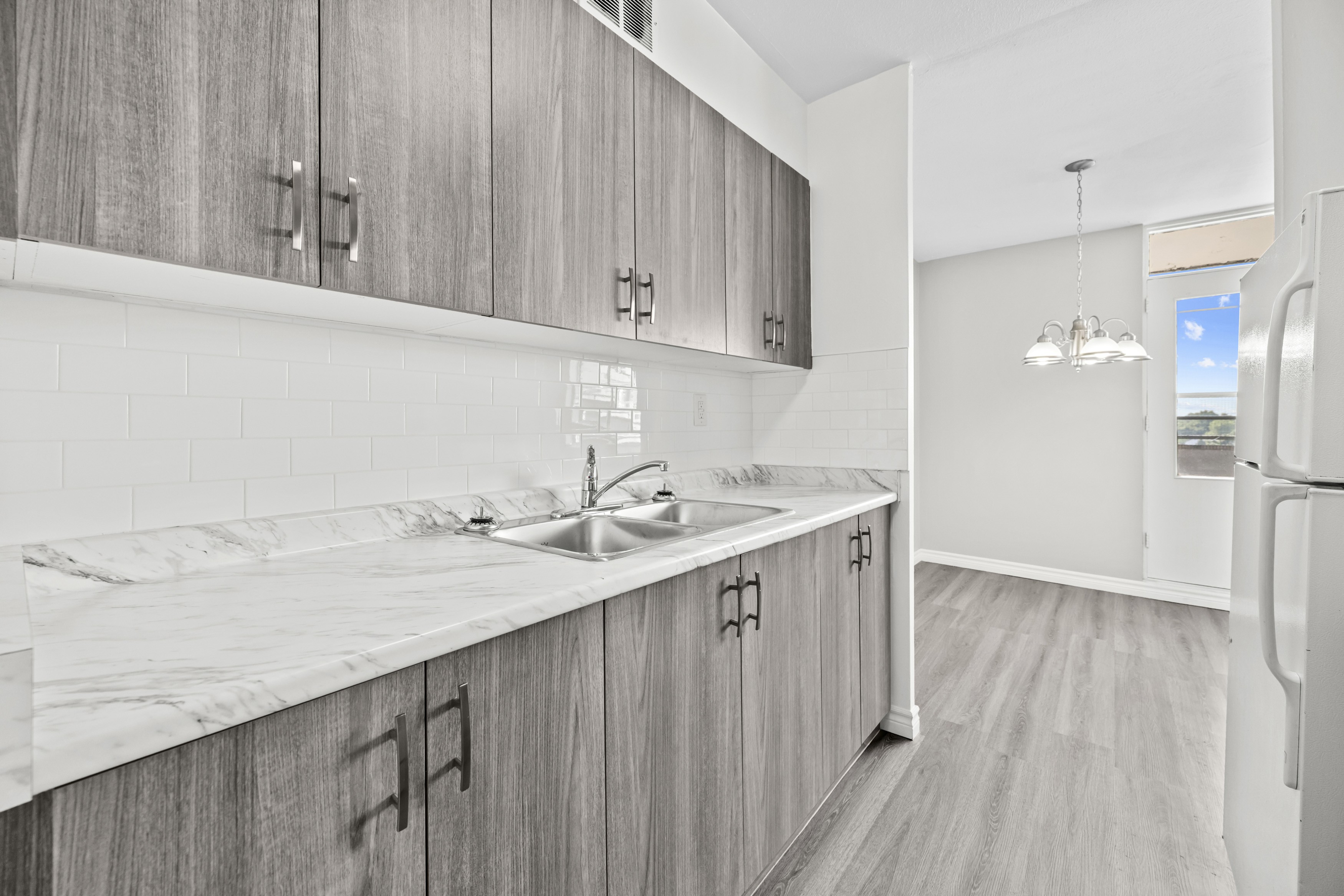 A kitchen with wooden cabinets and a marble countertop.