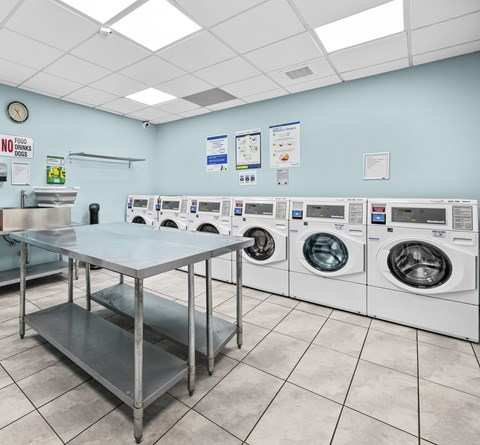 A laundromat with a row of washers and dryers.