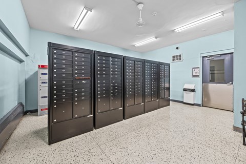 A row of black lockers in a room with a white floor.
