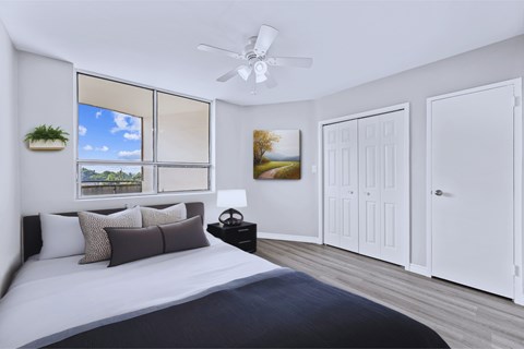 A bedroom with a large bed and a ceiling fan.