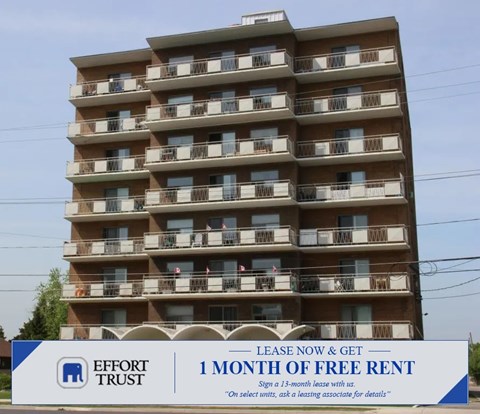 A tall apartment building with a sign in front that says "1 month of free rent".