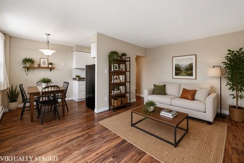 A living room with a couch, a dining table, and a coffee table.