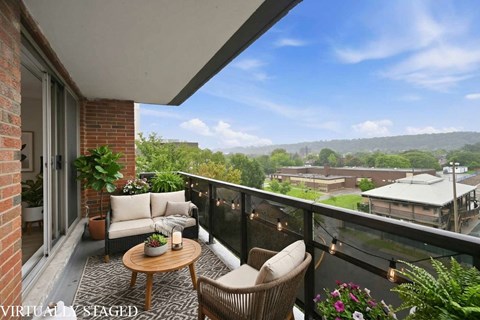 A balcony with a table and chairs overlooking a town.