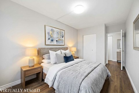 A bedroom with a bed, nightstands, and a painting on the wall.