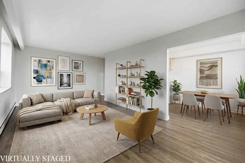 A living room with a couch, a chair, a coffee table, and a bookshelf.