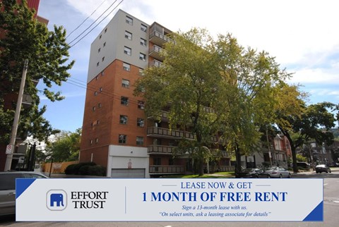 A large brick building with a sign in front that says "Lease Now & Get 1 Month Free Rent".