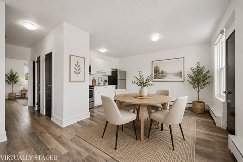 A dining room with a round table and chairs.
