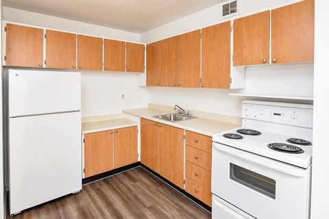 A kitchen with wooden cabinets and white appliances.