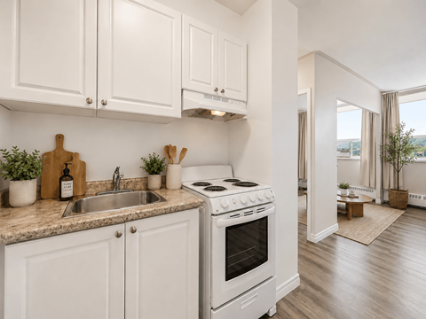 A kitchen with white cabinets and a stove top oven.