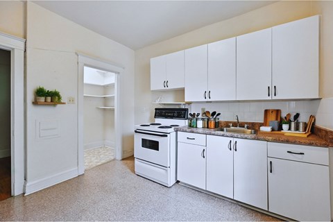 A kitchen with white cabinets and a black stove top oven.
