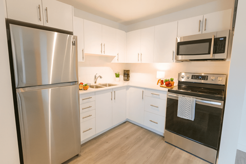 A modern kitchen with a stainless steel refrigerator and oven.