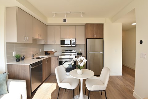 A kitchen with a table and chairs.