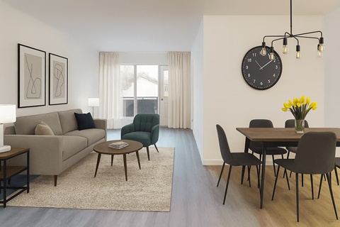 A living room with a grey couch, a green armchair, a coffee table, a dining table with chairs, a clock, and a vase of yellow flowers.
